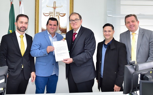 Fotografia do prefeito de Mangueirinha e o presidente do TRT-PR segurando o Termo de Cooperação. Ao lado, deles, três advogados da OAB de Palmas.
