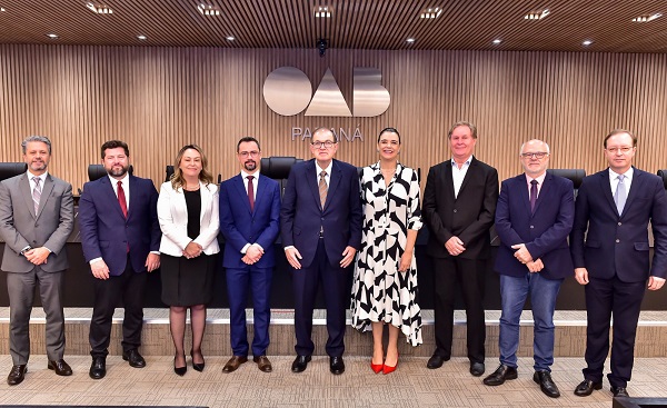 Fotografia de nove pessoas perfiladas ao lado uma da outra em uma sala da OAB-PR. São sete homens e duas mulheres. 