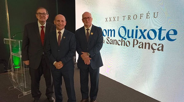 Fotografia de três homens vestindo ternos ao lado de um painel luminoso com a frase: XXI Troféu Dom Quixote e Sancho Pança. A partir da esquerda, o presidente do TRT-PR, desembargador Célio Waldraff; o  presidente do TRT-SC, desembargador Amarildo Carlos de Lima; e o presidente do TRT-RS, desembargador Ricardo Martins Costa.