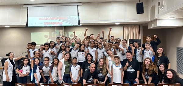 Fotografia de um grupo de cerca de 50 crianças com professores e servidores da Justiça do trabalho.