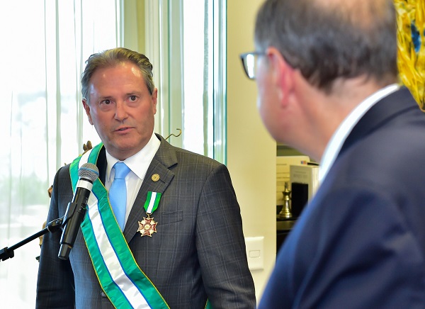 O presidente do TJ-PR, desembargador Luiz Fernando Tomasi Keppen, discursa em frente a um microfone e olha ao presidente do TRT-PR, desembargador Célio Horst Waldraff, que aparece de costas na foto. Ambos vestem terno. O desembargador Keppen utiliza faixa em verde e branco da Ordem das Araucárias e traz em uma das mãos o certificado.