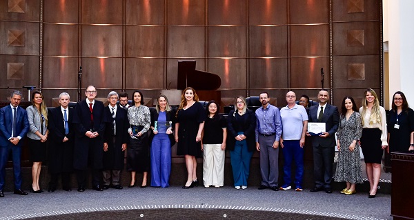 Fotografia do plenário principal do TRT-PR com 16 pessoas perfiladas lado a lado, sendo 9 mulheres e 7 homens.